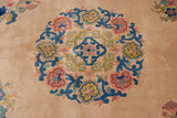 Detail of a plush vintage Japanese Peking rug with blush and cobalt floral roundel.