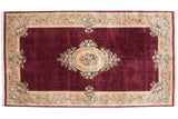 Japanese Savonnerie carpet, black cherry red field, ivory floral medallion, vine border, 9'11