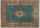 Vintage Japanese Savonnerie carpet corner with aqua green blue field and mauve floral border.