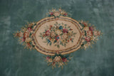 Ivory cameo medallion with colorful rose bouquets on an aqua green Savonnerie rug.