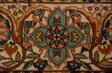 Detailed floral blossoms and arabesques in mint green, blush, and cobalt blue on an ivory pile.