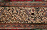 Intricate border detail showing floral top views and blossoms on a hand-knotted Turkish carpet.