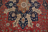 Crisp floral and leaf motifs in navy blue, copper, and red on a Turkish Kaisary carpet.