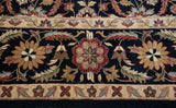 Vintage Agra carpet detail: black field with wine red, gold palmettes, and an ivory floral border.
