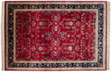 A traditional Mohajeran Sarouk rug with a rich red field and contrasting navy floral border.