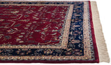 Intact selvage on the corner of a plush Mohajeran Sarouk carpet with a navy border and fringe.