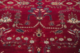 Delicate floral vinery and boteh motifs in blue and blush on the rich cherry red field of the carpet.