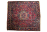 Vintage Tabriz square carpet with a roundel medallion, a dense cherry red field, and navy lotus flower border.