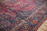 Angled view of the vintage Tabriz carpet's intricate millefleur field and lotus border.