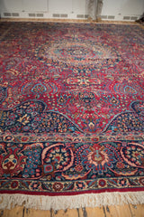 Close perspective of a vintage Tabriz rug's corner, showing the dense pile, ivory fringe, and navy floral border.