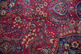 Dense millefleur pattern with navy and sky blue details on the cherry red wool pile.