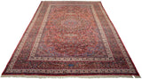 Perspective view of a fine vintage Meshed carpet, showing its full length, red field, and scrolling vinery.
