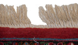 Hand-knotted ivory fringe and the rich cherry red border of a vintage Persian rug.