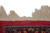 Close-up of the secured ivory fringe and hand-knotted border in cherry red and sapphire blue.