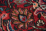 A close-up of the full, plush pile showing a floral motif in cherry red, navy, and raspberry tones.