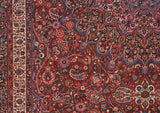 Close-up on the fine weave of a Persian Meshed carpet, showing detailed arabesques and botehs on a red field.