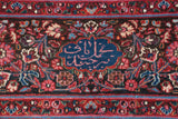 Close-up of the weaver's inscription in a blue cartouche on the fine Persian carpet's main border.