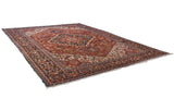 Detailed corner of the Vintage Bakshaish carpet, showcasing cherry red field, navy border, and geometric motifs.