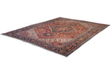 Vintage Bakshaish rug corner: intricate navy blue border, cherry red field, and white fringe.