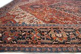 Vintage Bakshaish rug's navy border with vibrant geometric motifs and red field pattern.