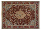 Stylized deer and birds within the burgundy forest scene of a vintage Persian Tabriz carpet corner.