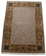 Savonnerie carpet with a tone-on-tone field and scrolling gold, blue, and terracotta border.