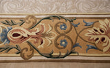 A detailed close-up of the scrolling floral arabesques and buds in the carpet's main border.