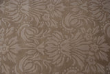Textured detail of shadow floral bouquets on a plush, tone-on-tone Savonnerie design carpet.