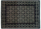 Staggered curvilinear Damask motifs in ivory and aubergine on a black vintage Indian carpet.
