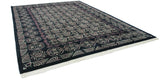 Angled perspective of a vintage Indian carpet showing the curvilinear relief of its Damask pattern.
