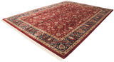 Corner detail of Mohajeran Sarouk carpet, rich wine red field, navy floral border, and fringe.