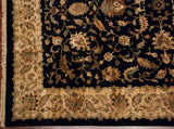 Agra carpet corner with ivory meandering border, deep black field, bronze and pale blue floral vinery.
