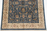 Section of a traditional Agra carpet, featuring a deep denim blue field with floral palmettes and a beige border.
