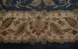Agra carpet's ivory main border with meandering vine, floral cross sections, and blue field.
