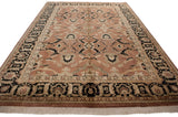 Agra rug corner showing light fringe, black border with ivory vinery, and bronze field motifs.