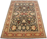 Angled perspective of a fine Indian Serapi carpet with large floral palmettes on a dark brown field.