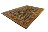 Angled view of a vintage Indian Serapi rug with floral palmettes on a dark chocolate brown field.