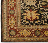Corner of a fine Indian Serapi carpet showing its brick red floral border and dark brown field.