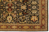 Corner of an Indian Serapi carpet with large floral palmettes on a dark chocolate brown field.