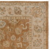 Indian Oushak rug corner showing bronze field, ivory border, delicate floral vinery.