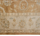 Indian Oushak rug border showing delicate floral vinery in ivory, bronze, and pale blue.
