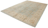 Corner of Indian Oushak carpet showing beige palmettes, vinery, powder blue field, and fringe.