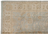 Detail of a corner with palmette and floral vinery on a powder blue Oushak rug.