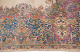 Kerman carpet detail: Rococo stylized floral border in ivory, blue, and bubble gum pink.