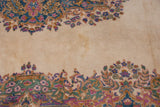 Detail of Vintage Kerman carpet showing ivory field with stain and colorful Rococo floral sprays.
