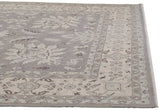 Curvilinear vinery and floral details in silver and ivory on the rug's outer border.