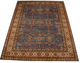 Angled view of a blue Pakistani carpet with a covered field of Caucasian geometric motifs.