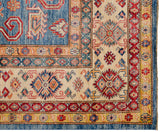 Corner of a fine Pakistani Caucasian carpet showing geometric rams horn motifs and colorful floral borders.