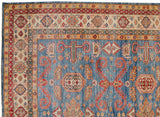 Intricate ivory border and blue field with ram's horn motifs on a Pakistani Caucasian carpet corner.