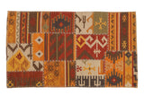 Geometric patchwork Kilim rug with warm brick red, saffron, and brown colors, cross-hatch stitched.